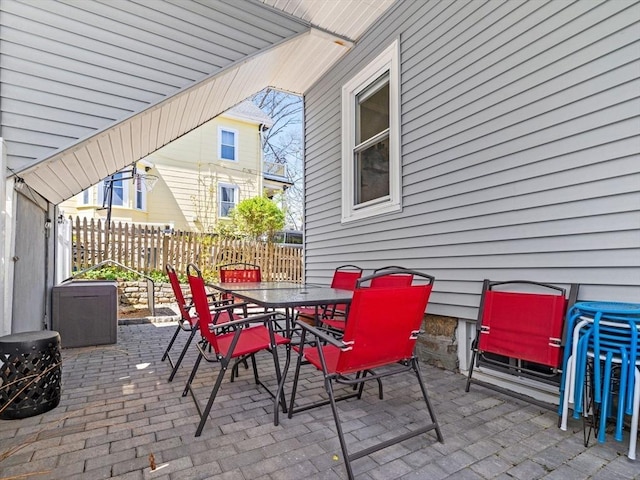 view of patio with central AC, fence, and outdoor dining space