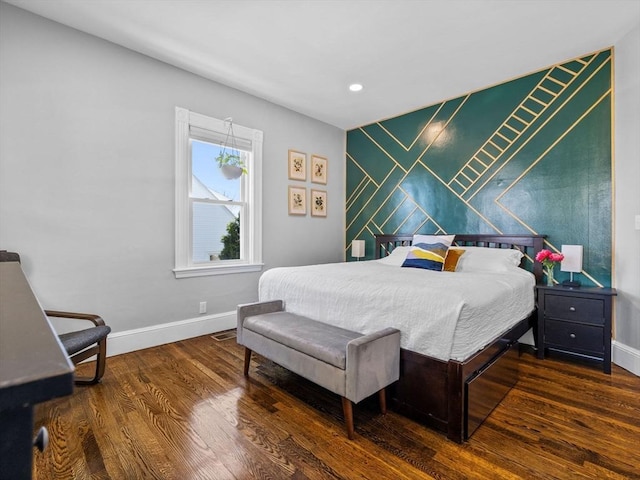 bedroom featuring baseboards, recessed lighting, an accent wall, and wood finished floors