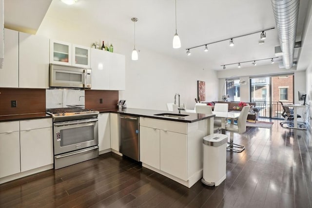 kitchen featuring white cabinets, sink, kitchen peninsula, and stainless steel appliances