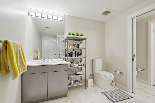 bathroom featuring tile patterned flooring, vanity, and toilet