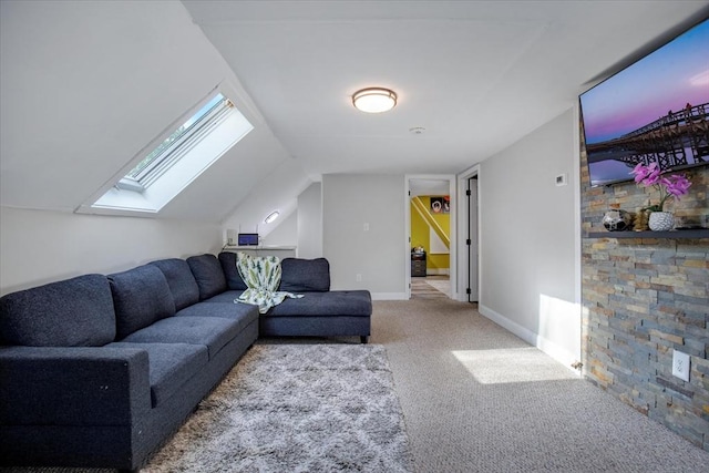 living area featuring a skylight, carpet flooring, baseboards, and lofted ceiling
