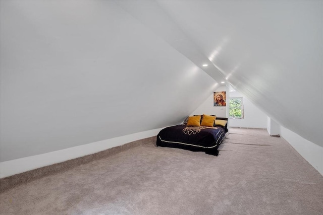 sitting room featuring vaulted ceiling and carpet flooring