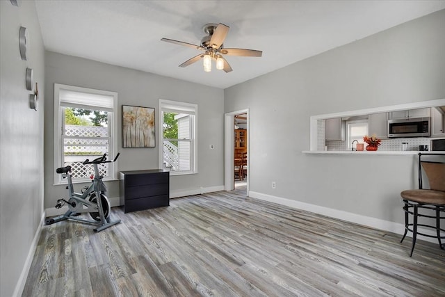 office with wood finished floors, a ceiling fan, baseboards, and a sink