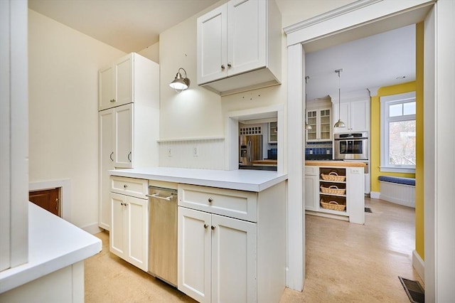 kitchen featuring white cabinetry, double oven, and pendant lighting