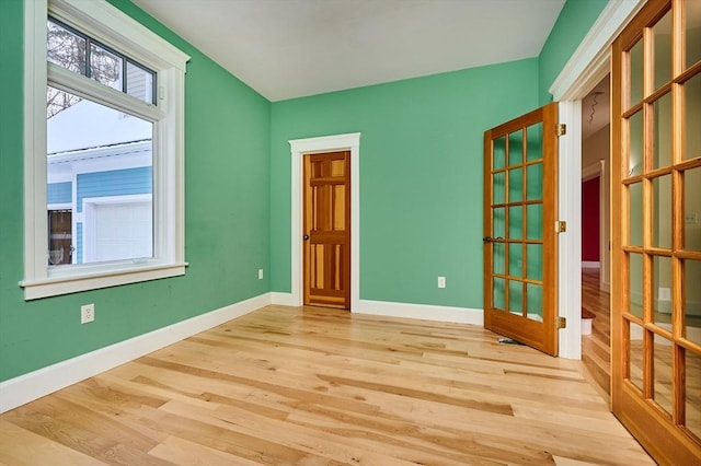 empty room featuring french doors and light hardwood / wood-style floors