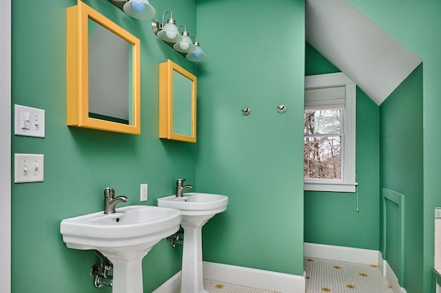 bathroom featuring double sink, lofted ceiling, and tile patterned floors