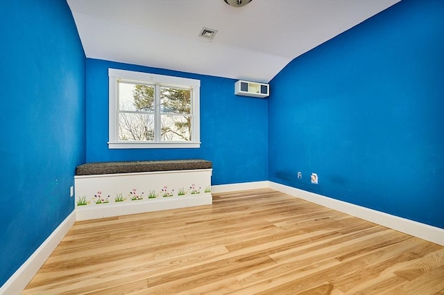 spare room with wood-type flooring and vaulted ceiling