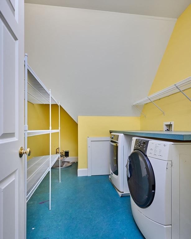 clothes washing area with washer and clothes dryer and carpet