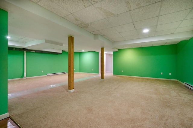 basement featuring baseboard heating, carpet flooring, and a drop ceiling