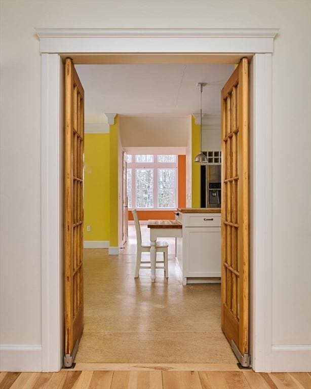 hall with crown molding and light wood-type flooring