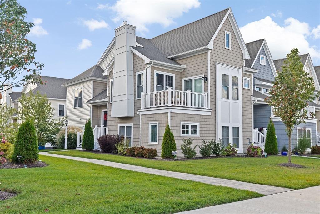 view of front of home with a balcony and a front yard