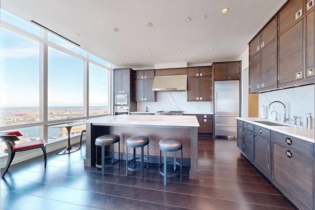 kitchen with a kitchen island, extractor fan, stainless steel appliances, dark wood-type flooring, and tasteful backsplash