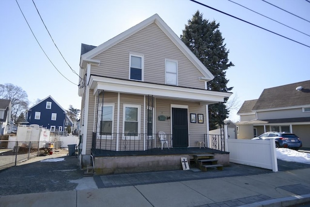 view of front of property featuring covered porch and fence