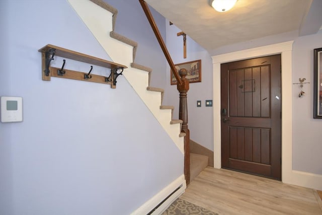 entrance foyer with baseboards, stairway, and wood finished floors