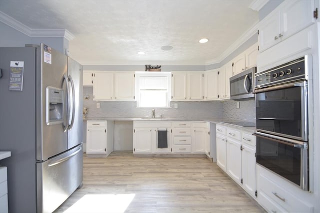 kitchen featuring a sink, white cabinetry, light wood-type flooring, black appliances, and crown molding