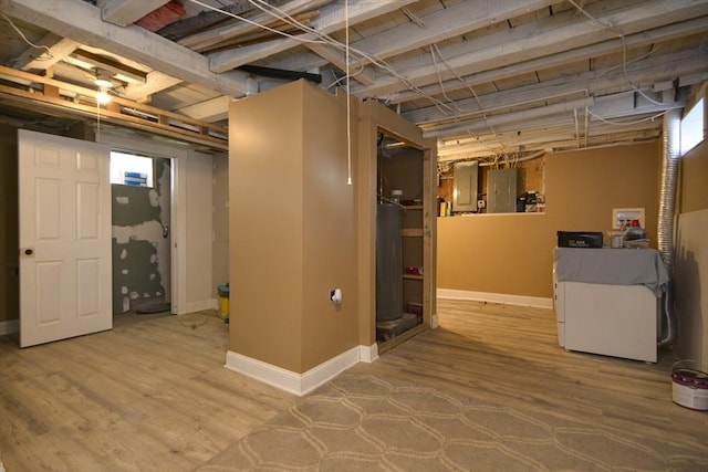 basement with electric panel, gas water heater, baseboards, and wood finished floors