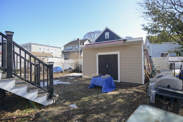 view of yard with an outbuilding, stairway, and fence