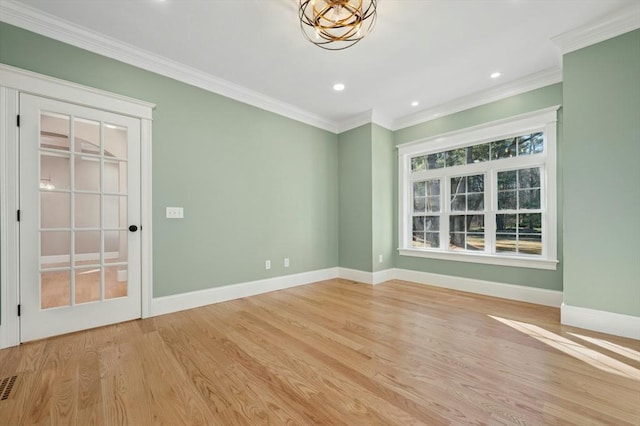 empty room with ornamental molding and light hardwood / wood-style flooring