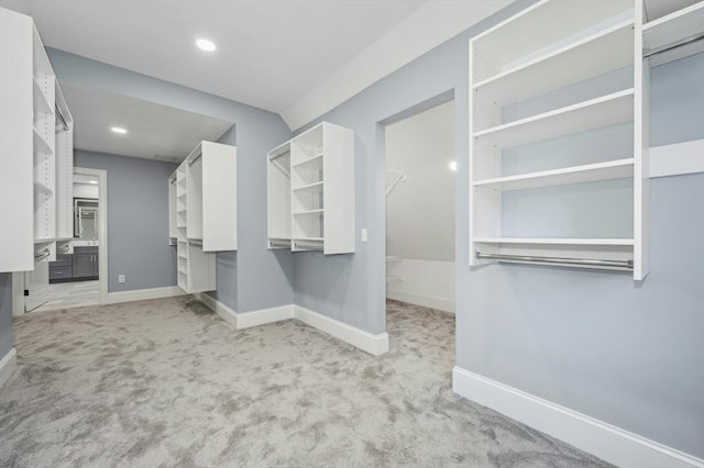 walk in closet with light colored carpet