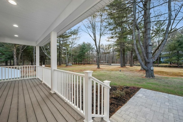 wooden terrace with a lawn and a porch