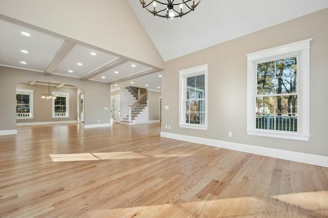 unfurnished living room featuring vaulted ceiling with beams, a chandelier, and light wood-type flooring