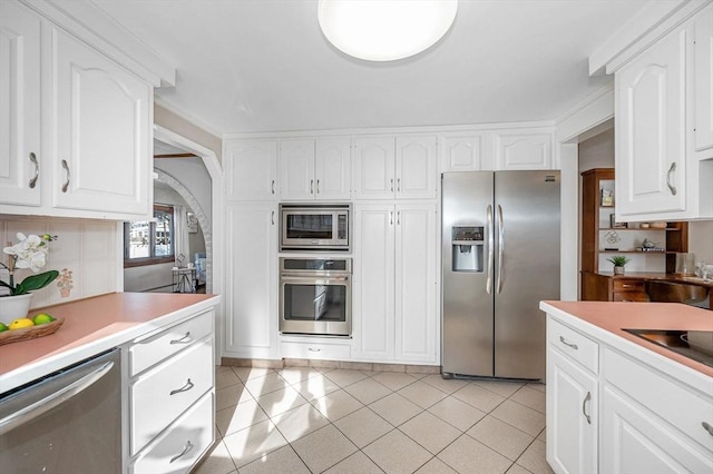 kitchen featuring light tile patterned flooring, white cabinets, and appliances with stainless steel finishes