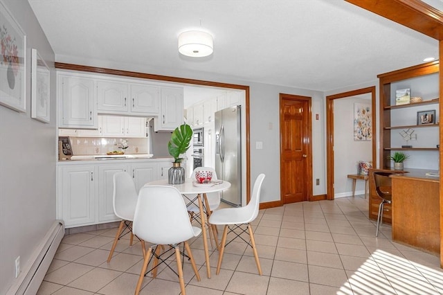 tiled dining room with a baseboard radiator