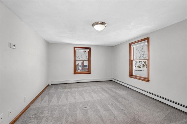 spare room with a baseboard heating unit and light colored carpet