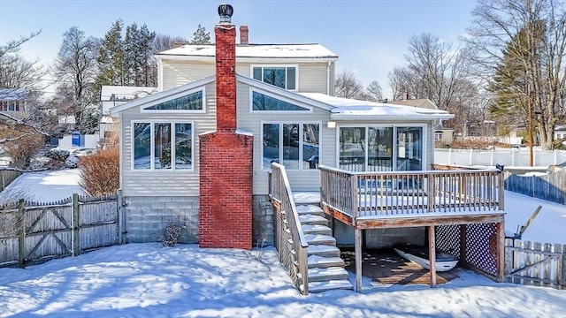 snow covered house with a deck