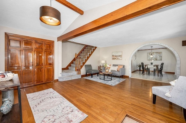 living room with vaulted ceiling with beams and wood-type flooring