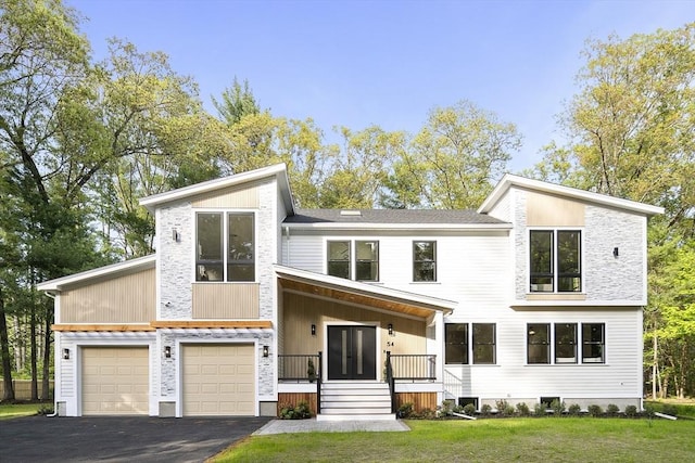 54 Stone Rd, Sudbury, MA 01776 - view of front of home with asphalt driveway, a front lawn, a porch, and a garage