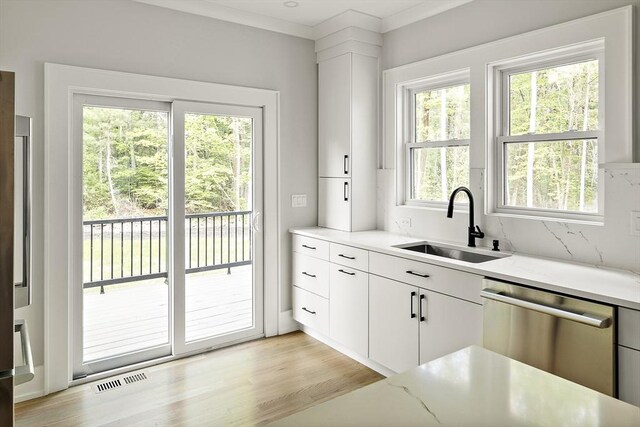 54 Stone Rd, Sudbury, MA 01776 - kitchen with stainless steel dishwasher, a sink, white cabinetry, light stone countertops, and light wood-type flooring