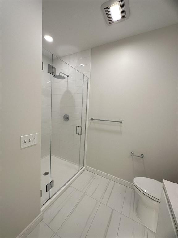 bathroom featuring tile patterned flooring, toilet, and a shower with door