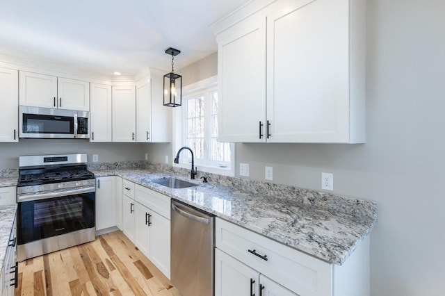 261/2 Cherry St, Spencer, MA 01562 - kitchen featuring stainless steel appliances, a sink, light wood-type flooring, light stone countertops, and white cabinetry