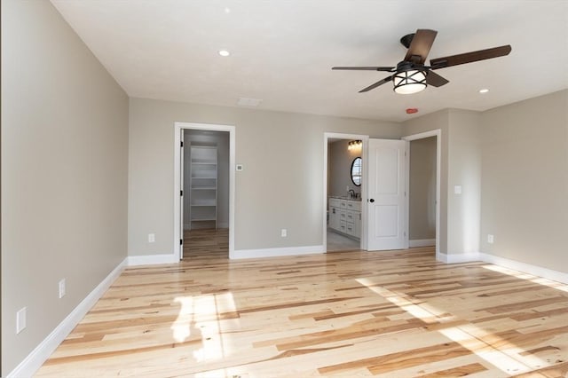 261/2 Cherry St, Spencer, MA 01562 - unfurnished bedroom featuring a walk in closet, baseboards, connected bathroom, and light wood finished floors