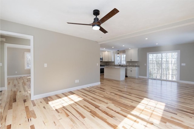 261/2 Cherry St, Spencer, MA 01562 - unfurnished living room featuring light wood-style flooring, baseboards, a sink, and ceiling fan