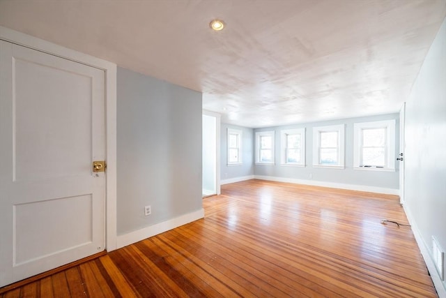 empty room featuring baseboards and light wood finished floors