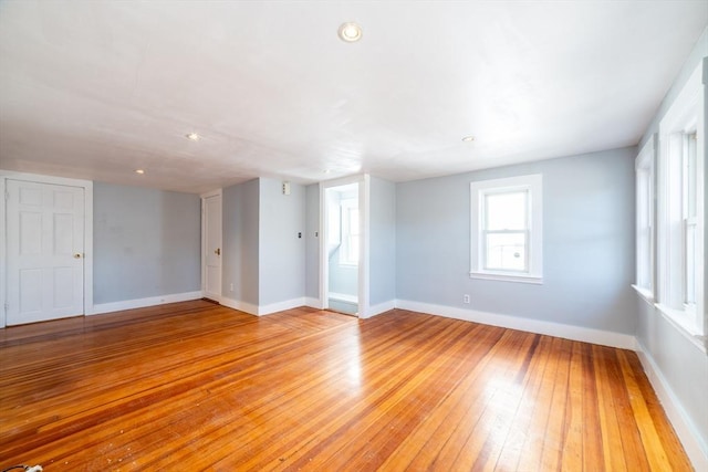 empty room featuring light wood finished floors, baseboards, and recessed lighting