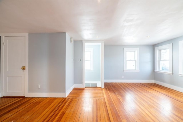 empty room with baseboards and light wood finished floors