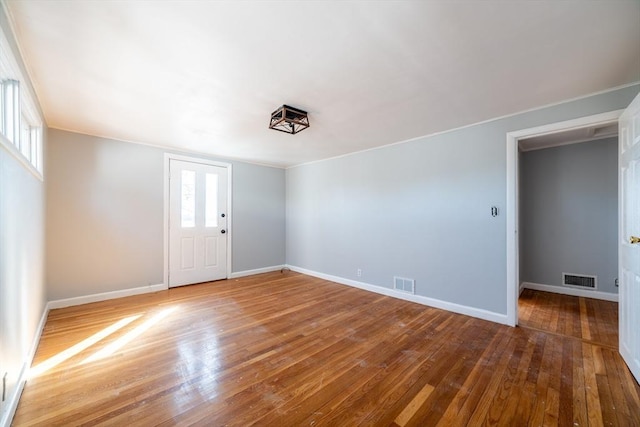 spare room with baseboards, visible vents, and hardwood / wood-style floors