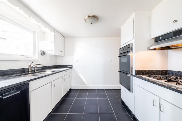 kitchen featuring under cabinet range hood, dark tile patterned floors, a sink, black appliances, and dark countertops