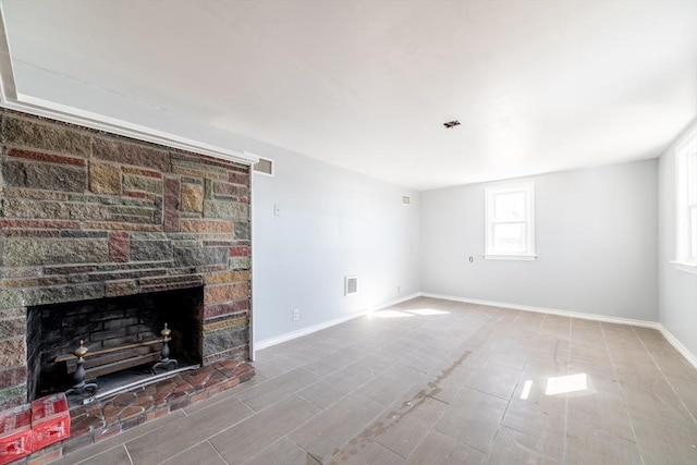 unfurnished living room featuring visible vents, a fireplace, and baseboards