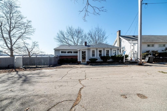 view of front of house with a chimney and fence