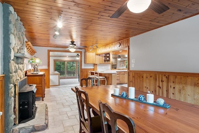 1 Sheffield Cir, Andover, MA 01810 - dining space with ceiling fan, wainscoting, stone tile floors, a wood stove, and wood ceiling