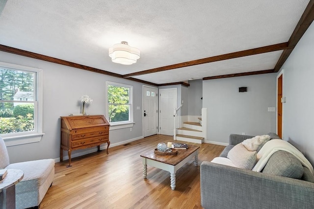 1 Sheffield Cir, Andover, MA 01810 - living room with healthy amount of natural light, light wood-type flooring, stairs, a textured ceiling, and beam ceiling