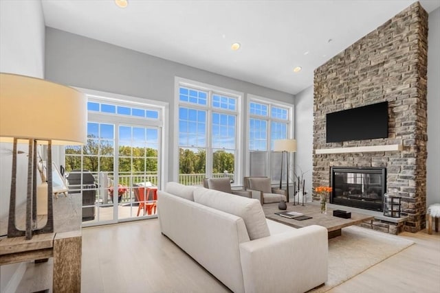 21 Brand Blvd Unit 21, Scituate, MA 02066 - living room featuring wood finished floors, a stone fireplace, a towering ceiling, and recessed lighting