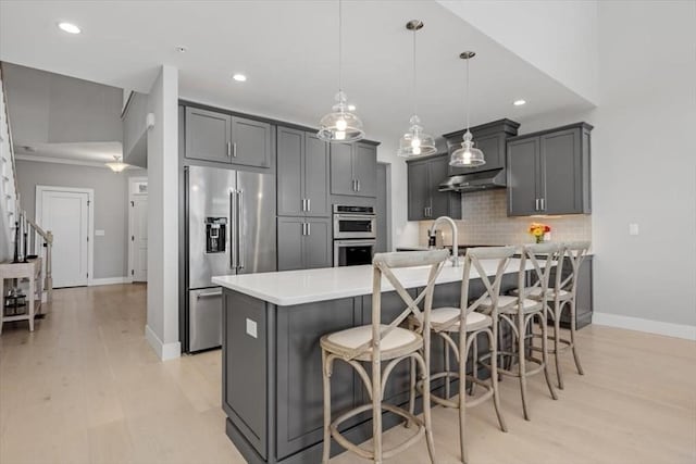 21 Brand Blvd Unit 21, Scituate, MA 02066 - kitchen featuring appliances with stainless steel finishes, under cabinet range hood, baseboards, gray cabinetry, and tasteful backsplash