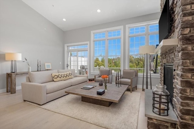 21 Brand Blvd Unit 21, Scituate, MA 02066 - living room featuring a fireplace, a high ceiling, wood finished floors, baseboards, and recessed lighting