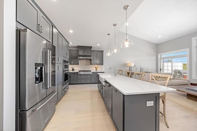 21 Brand Blvd Unit 21, Scituate, MA 02066 - kitchen with stainless steel appliances, a sink, a kitchen bar, under cabinet range hood, and gray cabinetry