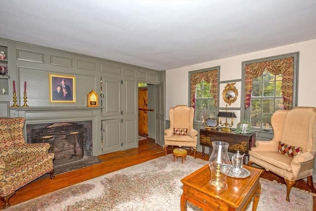 living room with a high end fireplace and wood finished floors